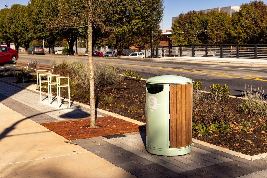 A branded trash can on the sidewalk that was added during the downtown revitalization project.